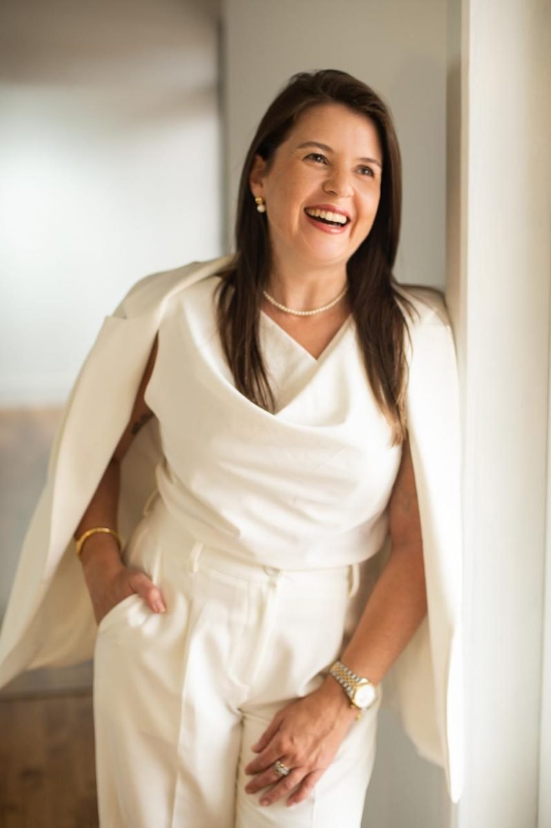 Retrato de Ana Paula Melo sorrindo, com conjunto branco